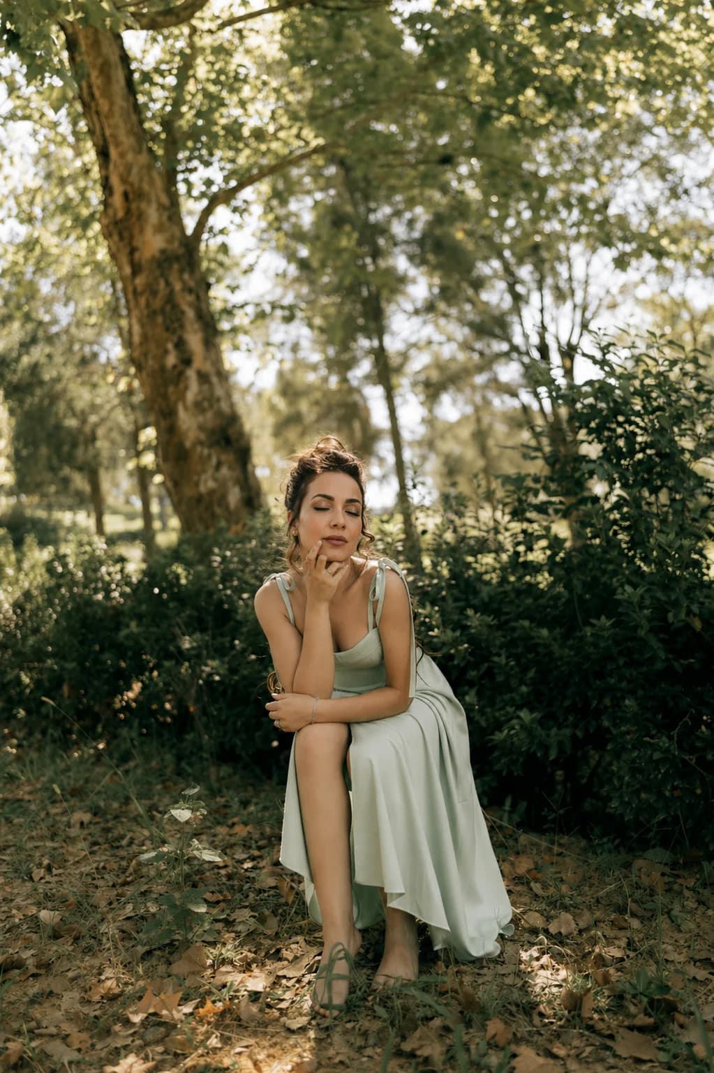 Femme apaisée, yeux fermés, assise dans la nature