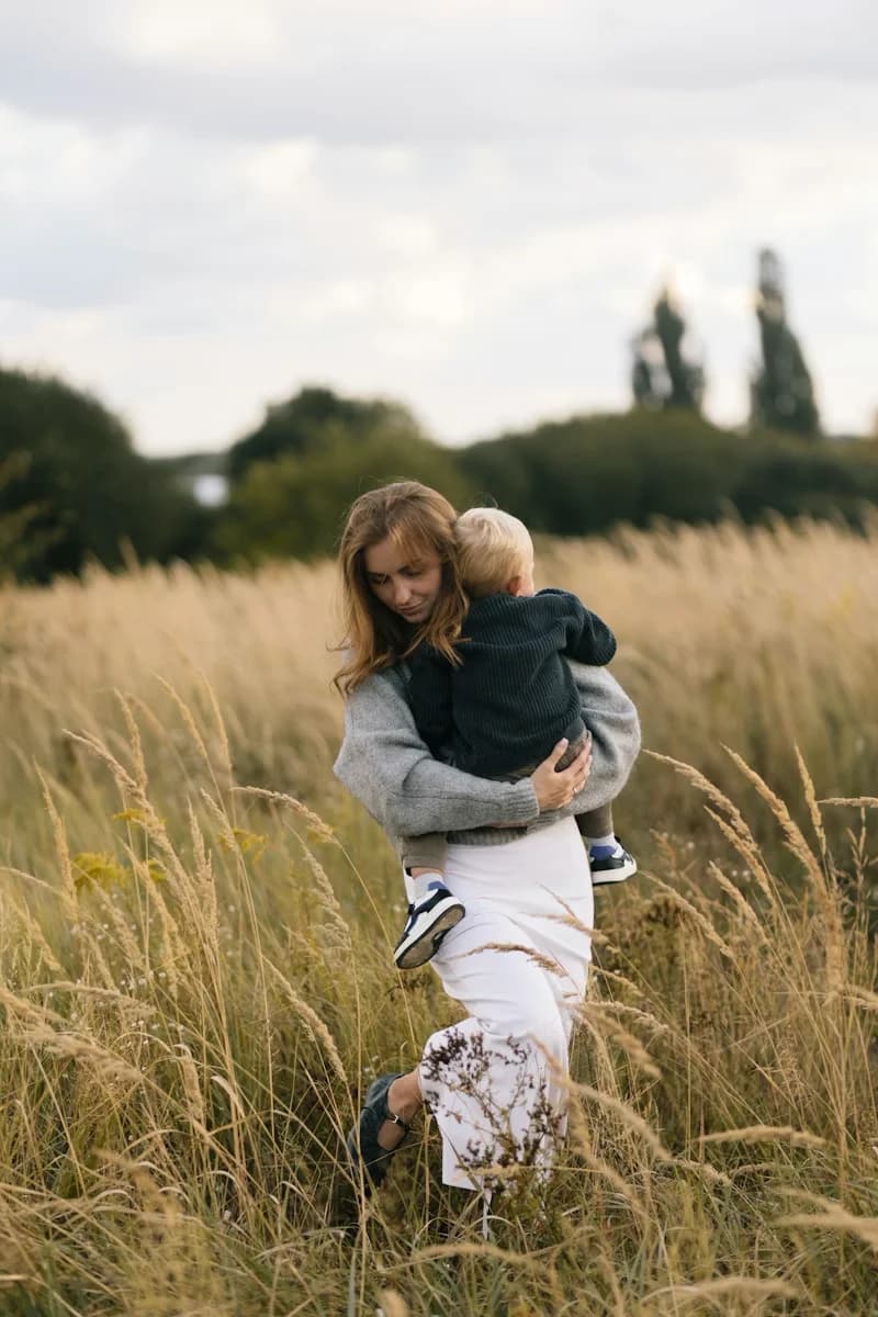 Mère portant son enfant dans un champ naturel